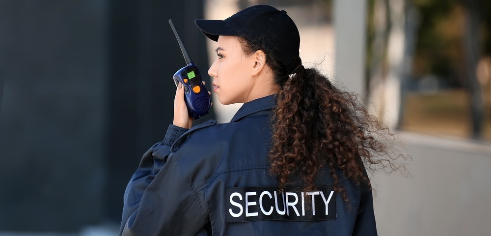 Woman security guard speaking on walkie talkie