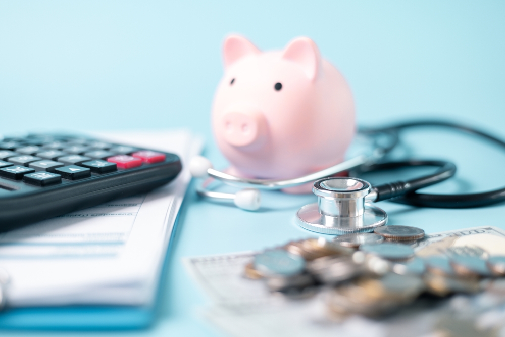 Image of piggy bank with calculator, stethoscope, and medical bills